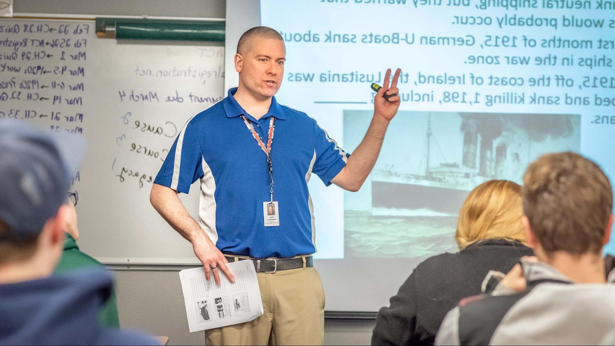 Social studies teacher in front of class teaching high school students