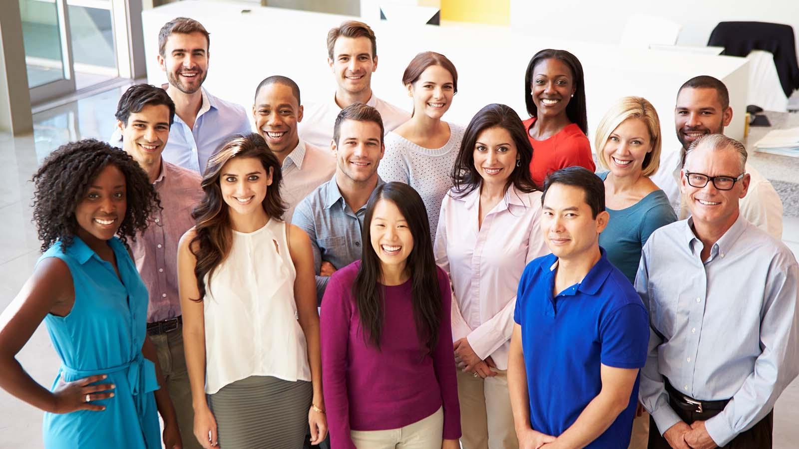 Portrait of multi-cultural office staff standing in lobby casually